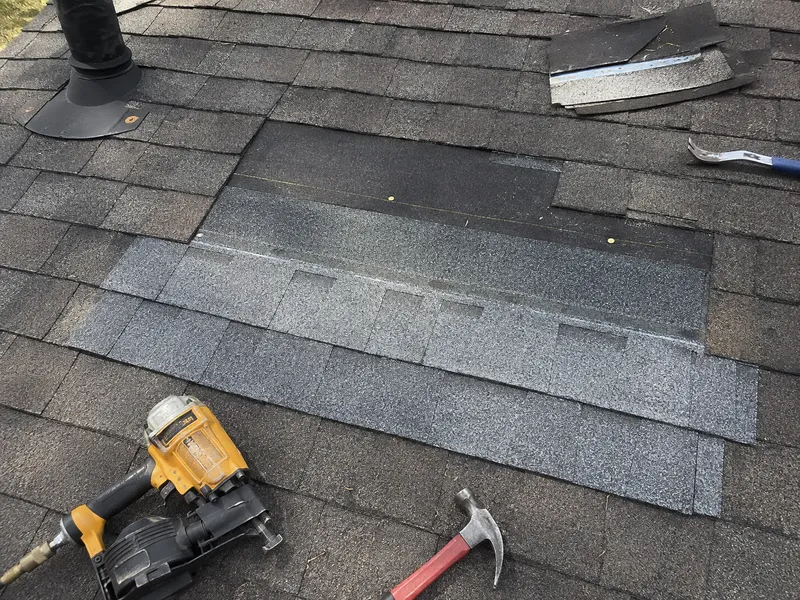 A roofer repairing asphalt shingles on a home in Milwaukee